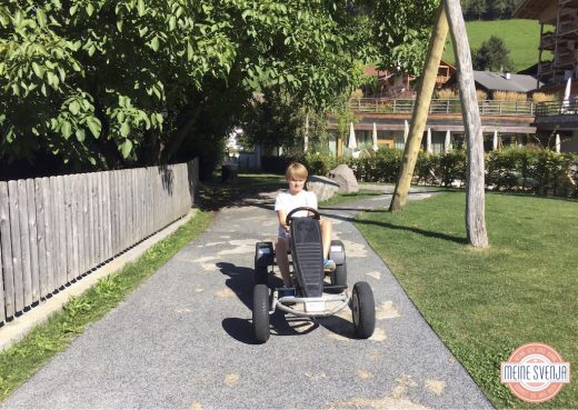 Outdoor Spielplatz im Sonnwies Familienhotel Südtirol mit Kettcar Parcour